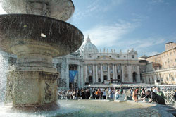 As sunlight shimmers through the falling water, a visitor to St. Peter’s Square in Rome dips his hand into a fountain designed and built by Carlo Maderno in 1613.