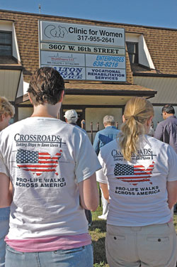 Crossroads walkers Beth Ann Flessner, left, from St. Francis of Assisi Parish in Madison, Miss., and Alzbeta Voboril from St. Francis of Assisi Parish in Wichita, Kan., pray with the archdiocesan Helpers of God’s Precious Infants on July 21 in front of an abortion clinic in Indianapolis.	