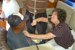 Registered nurse Connie Herr looks at her watch to track the heart rate of a patient seeking care through the Gennesaret Free Clinics, a volunteer organization started by Dr. Jim Trippi, a member of St. Thomas Aquinas Parish of Indianapolis. (Submitted photo)	