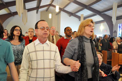 St. Gabriel the Archangel parishioners Stephen Tsareff and Sharon Porter of Indianapolis hold hands as they pray the Lord’s Prayer during the Mass of Dedication on Feb. 6 at St. Gabriel the Archangel Church in Indianapolis. (Photo by Mary Ann Wyand)