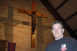 In creating the bronzed figure of Christ on the cross at Immaculate Heart of Mary Church in Indianapolis, firefighter and sculptor Ryan Feeney wanted to depict Jesus as a symbol of strength. (Photo by John Shaughnessy)