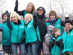 Members of the Catholic Charities Disaster Response Team ride a float during a March 2 parade in Henryville commemorating the one-year anniversary of southern Indiana’s tornadoes. Father Steven Schaftlein, pastor of St. Francis Xavier Parish in Henryville and St. Michael Parish in Charlestown, sits on the far right of the float. (Submitted photo)