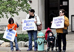 Sara Cabrera, left, Maria Hernandez, Daniel Cabrera and Josefina Garcia, all members of St. Ann Parish in Indianapolis, participate in the Life Chain on Meridian Street in Indianapolis following the Respect Life Sunday Mass on Oct. 6. (Photo by Natalie Hoefer)