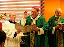 Archbishop Joseph W. Tobin blesses the new library at St. Matthew the Apostle School in Indianapolis on Nov 17. Assisting the archbishop during the ceremony is St. Matthew parishioner Loral Tansy. (Submitted photo)