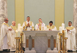 Then-Bishop Charles C. Thompson elevates the Eucharist during a special Latino Day of Mercy Mass on Aug. 6, 2016, at St. Benedict Cathedral in Evansville, Ind., to celebrate the Holy Year of Mercy. (Photo courtesy The Message)