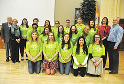 Recipients of scholarships for 2018 from the Brooke Nicole Lahr Memorial Fund for International Mission Work pose on Feb. 26 in the Archbishop Edward T. O’Meara Catholic Center in Indianapolis. They are, from left, front row: Allison Stump, Lainey Scroggins, Lily Johnson, Marta Schmitz and Sydney Traylor. Middle row: Shawn (Chandler) Sims, Sarah Wood, Abby Harkness, Malorie Weisenbach and Sarah Scheidler. Back row: Marguerite McMahon, Michael McNulty, Morgan Sell, Katie Barnes, Parker Williams, Nicholas Sellers and Maggie Peck. Colleen and Mark Lahr, Brooke’s parents, pose at right. Dave and Sandy Lahr, grandparents of Brooke, pose at left. (Photo by Sean Gallagher)