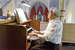 Don Gutzwiller plays the organ at St. Peter Church in Franklin County on July 27. Earlier this year, Guzwiller, 94, retired from accompanying liturgies at St. Peter and at the St. Paul campus of All Saints Parish in Dearborn County after 81 years of ministry. (Photo by Sean Gallagher)