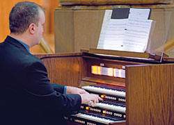 Andrew Motyka, director of archdiocesan and cathedral liturgical music, plays the organ for his sister-in-law’s wedding Mass at St. Mary Church in Indianapolis in October 2019. (Photo credit: Amy Counts Photography)