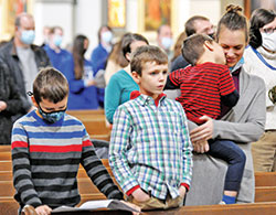 A mother and her three sons take part in a 2021 Mass at St. John the Evangelist Church in Indianapolis. (Criterion file photo by Natalie Hoefer)