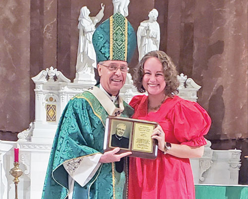 Emily Mingus, a member of St. Joan of Arc Parish in Indianapolis, beams as she receives the Archbishop O’Meara Respect Life Award from Archbishop Charles C. Thompson during the Respect Life Mass at SS. Peter and Paul Cathedral in Indianapolis on Oct. 6. (Photo by Natalie Hoefer)