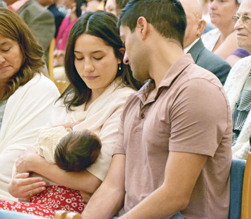 Maria and Anthony Neari, members of St. John the Evangelist Parish in Indianapolis, look lovingly at their son Salvatore during the archdiocese’s 40th annual Wedding Anniversary Mass in SS. Peter and Paul Cathedral in Indianapolis on Aug. 25. (Photo by Natalie Hoefer) 